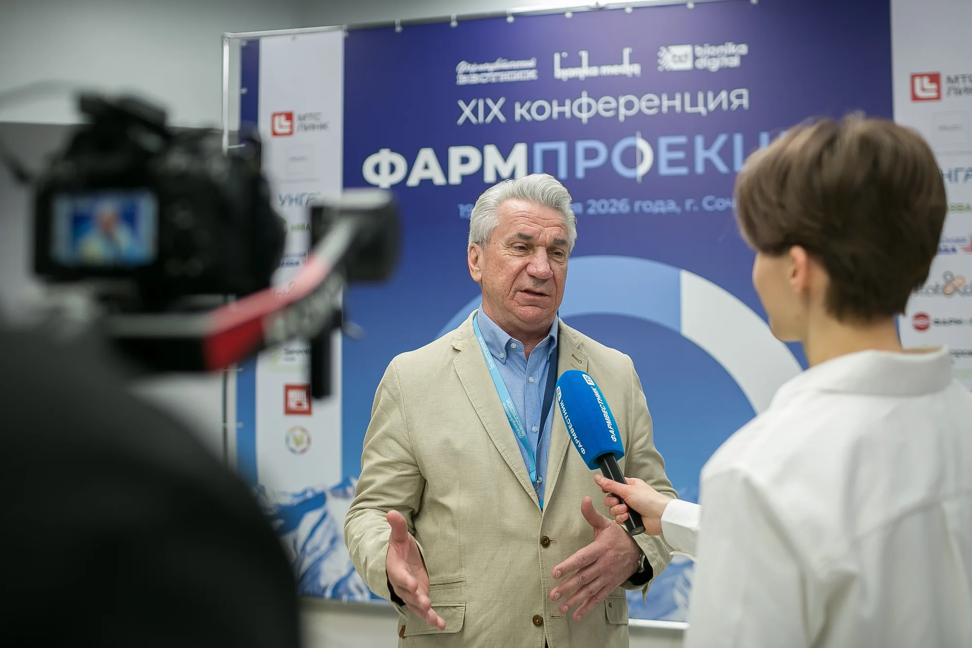 Съёмка интервью у оформления конференции